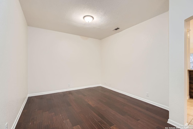 spare room featuring hardwood / wood-style floors and a textured ceiling