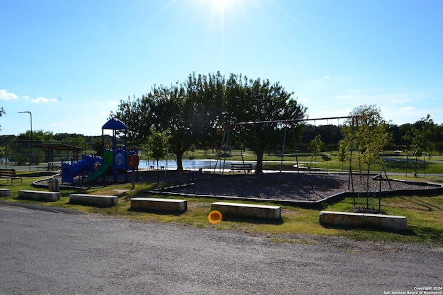 view of community with a playground and a water view