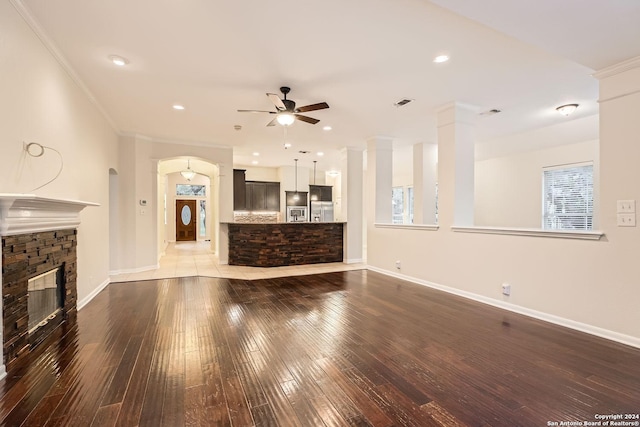 living room with ceiling fan, a fireplace, crown molding, and wood-type flooring