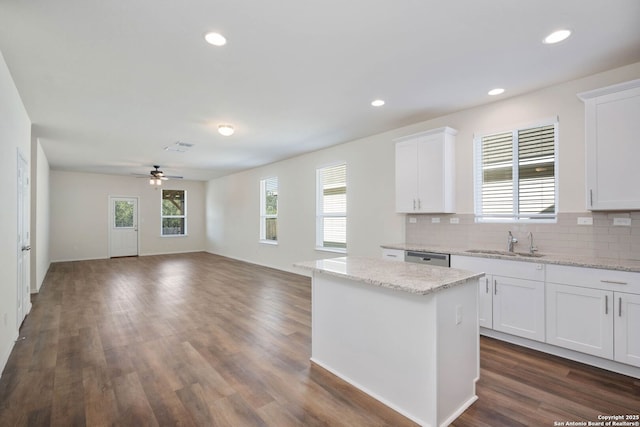 kitchen featuring sink, ceiling fan, tasteful backsplash, a kitchen island, and white cabinetry