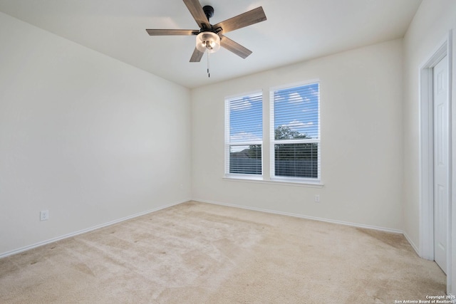 carpeted spare room with ceiling fan