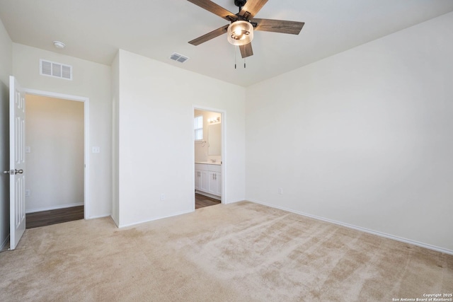 unfurnished bedroom with ensuite bath, ceiling fan, and light colored carpet