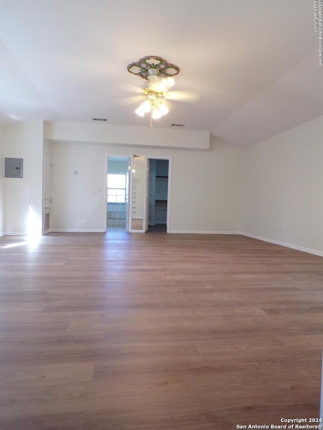 spare room featuring hardwood / wood-style floors, electric panel, ceiling fan, and lofted ceiling