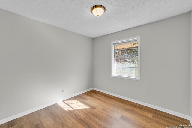 empty room featuring wood-type flooring and a textured ceiling