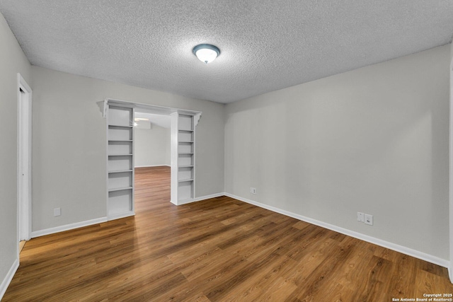 unfurnished bedroom featuring a textured ceiling, a closet, and dark wood-type flooring