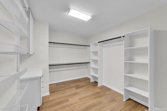 spacious closet featuring light hardwood / wood-style flooring