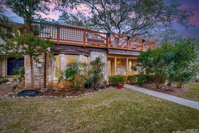 view of front of property featuring a lawn and a deck