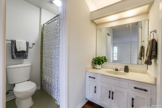 bathroom featuring a textured ceiling, toilet, vanity, and tile patterned flooring