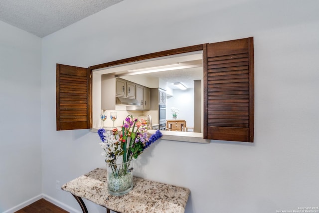 interior details featuring a textured ceiling and stainless steel oven