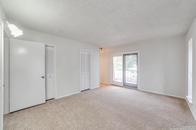 spare room with a textured ceiling and light carpet