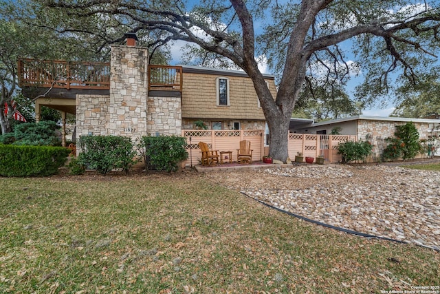 back of property with a wooden deck and a yard