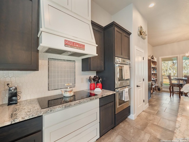 kitchen featuring premium range hood, black electric stovetop, white cabinets, double oven, and dark brown cabinets