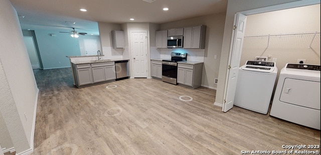 kitchen with independent washer and dryer, gray cabinetry, and appliances with stainless steel finishes