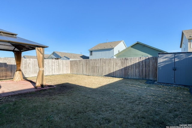 view of yard with a gazebo, a storage shed, and a patio