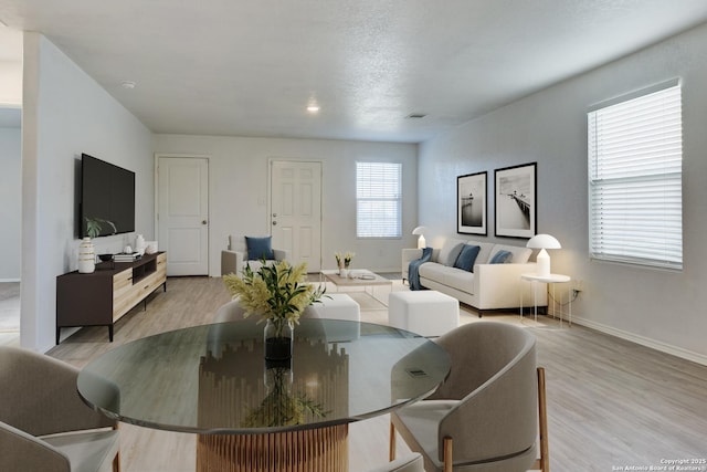 dining area featuring light wood-type flooring and plenty of natural light