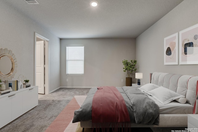 bedroom featuring light carpet and a textured ceiling