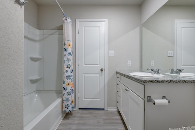 bathroom featuring hardwood / wood-style flooring, vanity, and shower / bathtub combination with curtain