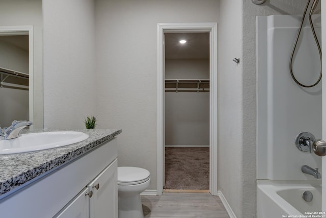 full bathroom with toilet, hardwood / wood-style flooring, vanity, and bathtub / shower combination