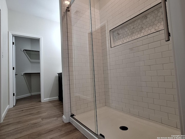 bathroom featuring hardwood / wood-style flooring and a shower with door