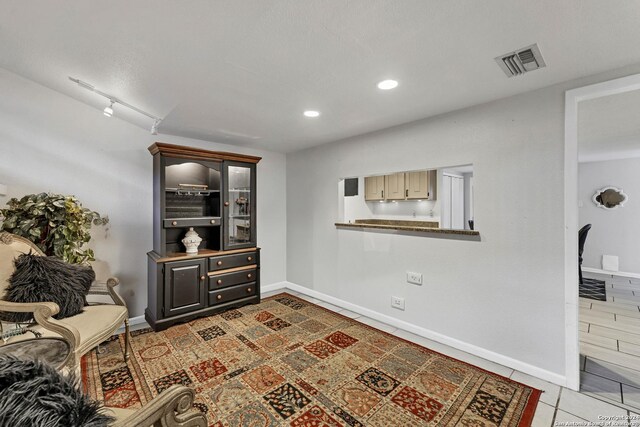 sitting room featuring light tile patterned floors and track lighting