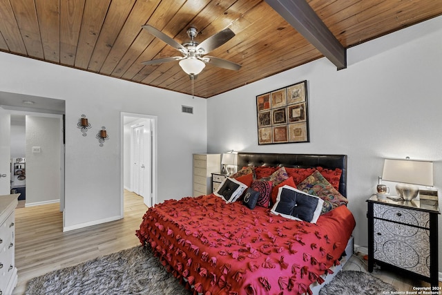 bedroom featuring beam ceiling, ceiling fan, light hardwood / wood-style floors, and wooden ceiling