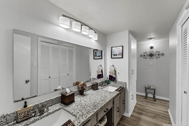 bathroom with vanity, wood-type flooring, and a textured ceiling