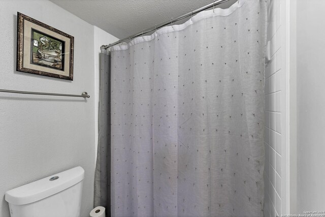 bathroom with toilet and a textured ceiling