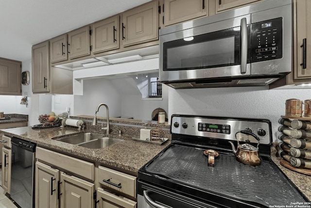 kitchen with sink, dark stone counters, and appliances with stainless steel finishes