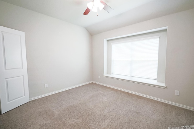 carpeted empty room with ceiling fan and vaulted ceiling