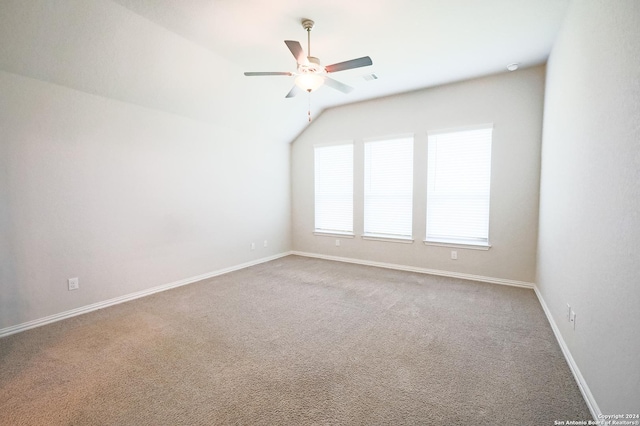 carpeted empty room with ceiling fan and vaulted ceiling