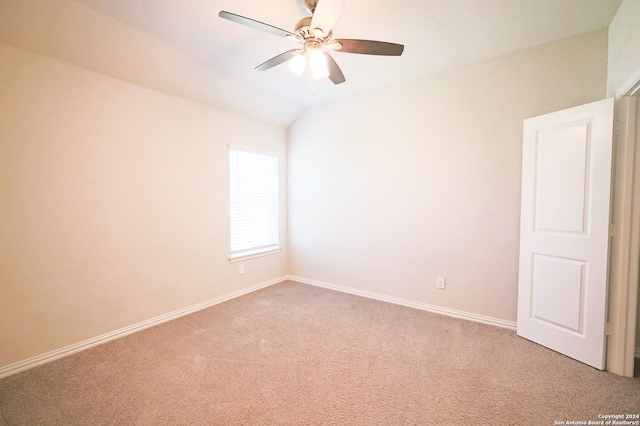 carpeted spare room with ceiling fan and vaulted ceiling