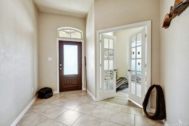 entryway with light tile patterned floors and french doors