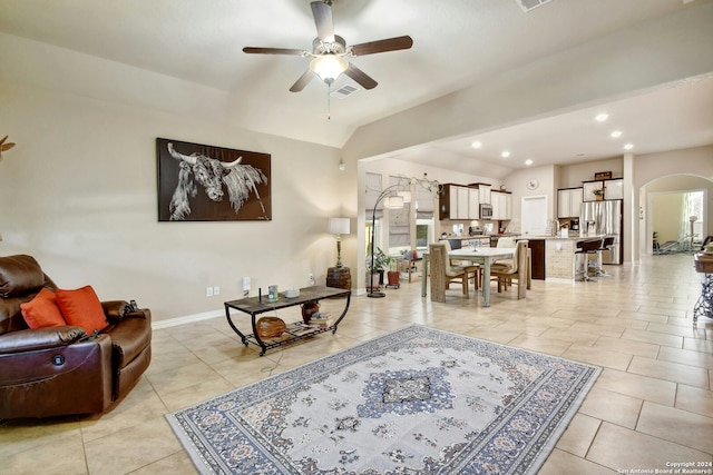 living room featuring light tile patterned floors, vaulted ceiling, and ceiling fan