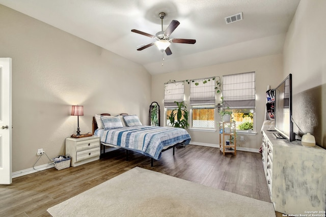 bedroom with ceiling fan, dark wood-type flooring, and vaulted ceiling