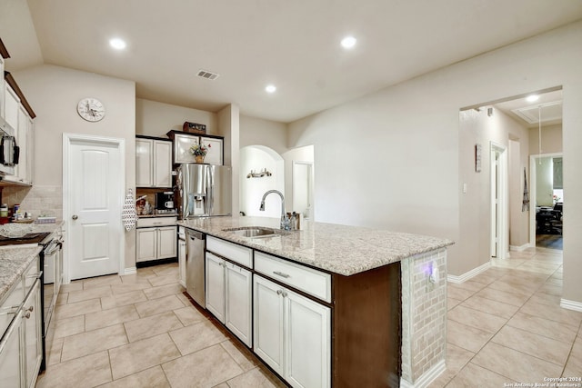 kitchen with backsplash, a kitchen island with sink, sink, light tile patterned floors, and stainless steel appliances