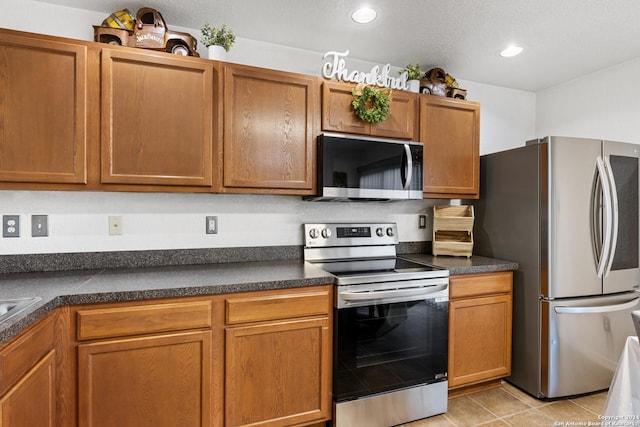 kitchen with stainless steel appliances and light tile patterned flooring