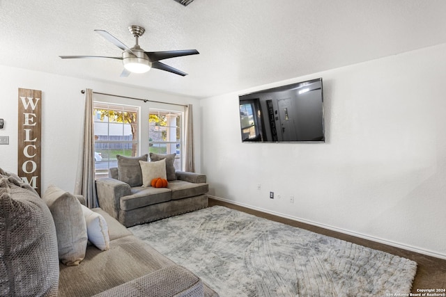 living room with a textured ceiling and ceiling fan