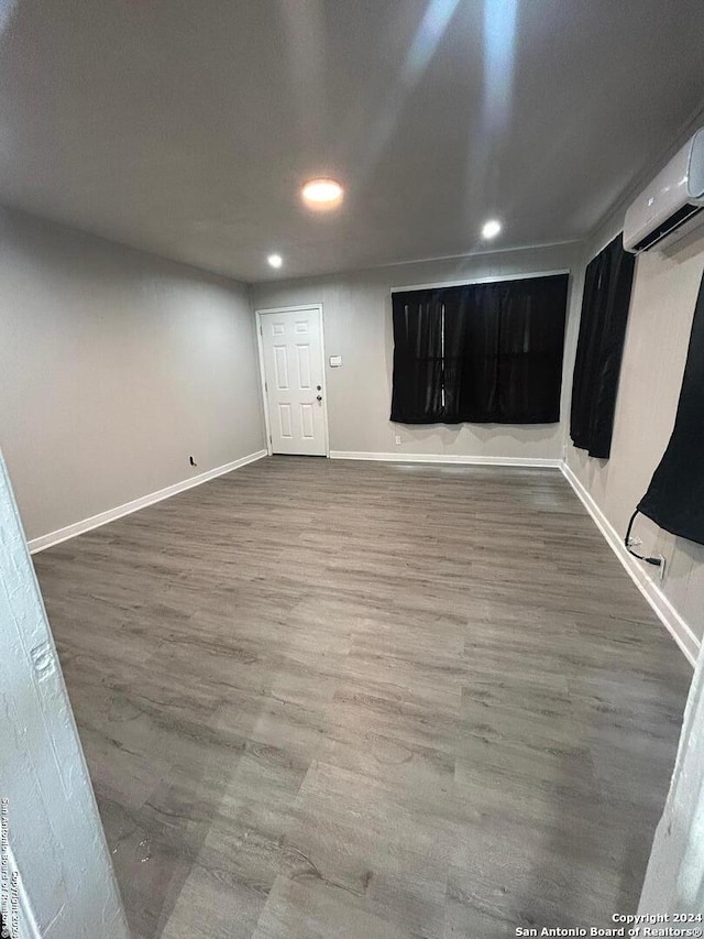 interior space featuring wood-type flooring and a wall mounted AC