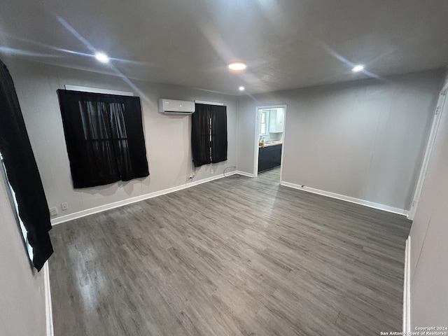 spare room featuring dark hardwood / wood-style flooring and a wall mounted air conditioner