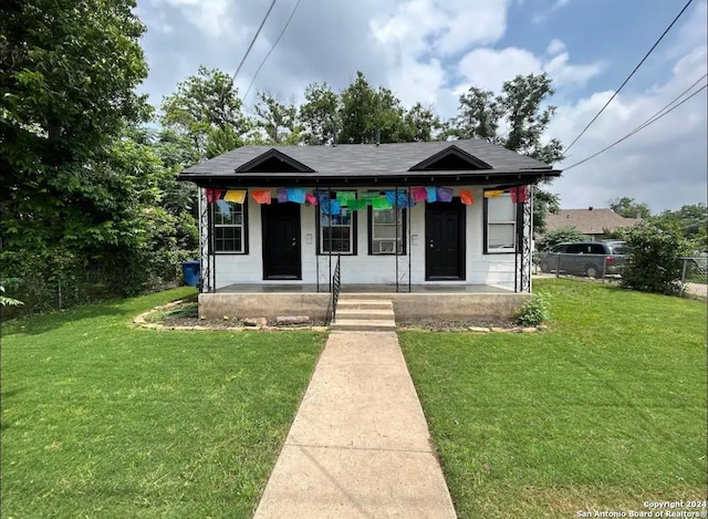 bungalow featuring covered porch and a front lawn