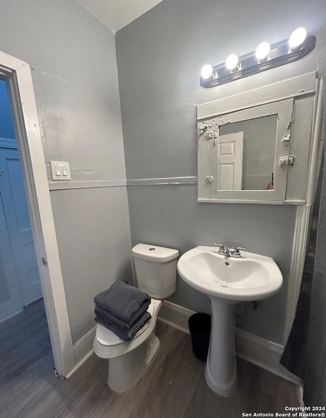 bathroom featuring toilet, wood-type flooring, and sink