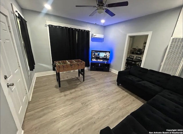 living room featuring ceiling fan and light hardwood / wood-style floors