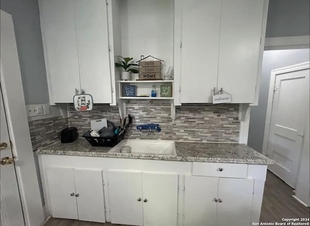 kitchen featuring white cabinets, decorative backsplash, and sink