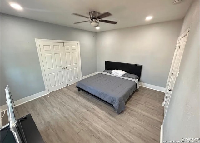 bedroom featuring ceiling fan, a closet, and hardwood / wood-style flooring