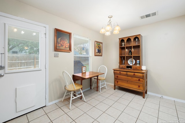 tiled dining room with a chandelier