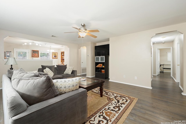 living room featuring ceiling fan and dark wood-type flooring