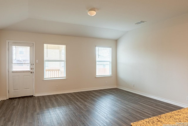 empty room featuring lofted ceiling and dark wood-type flooring