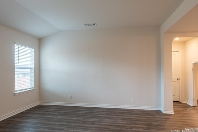 empty room featuring lofted ceiling and dark wood-type flooring