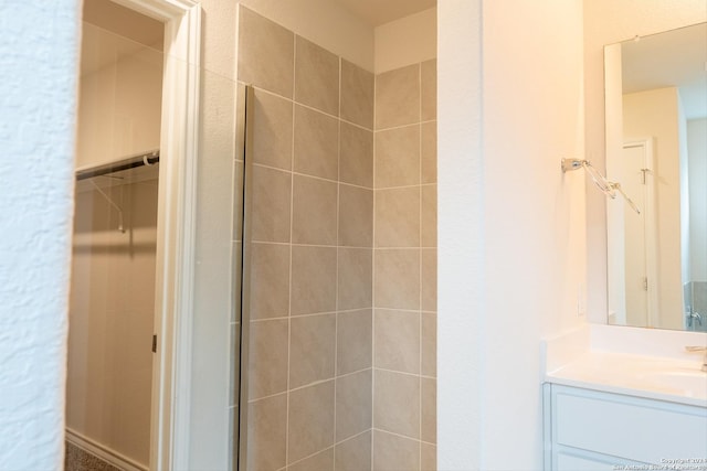 bathroom featuring vanity and tiled shower