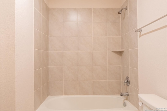 bathroom with tiled shower / bath and toilet